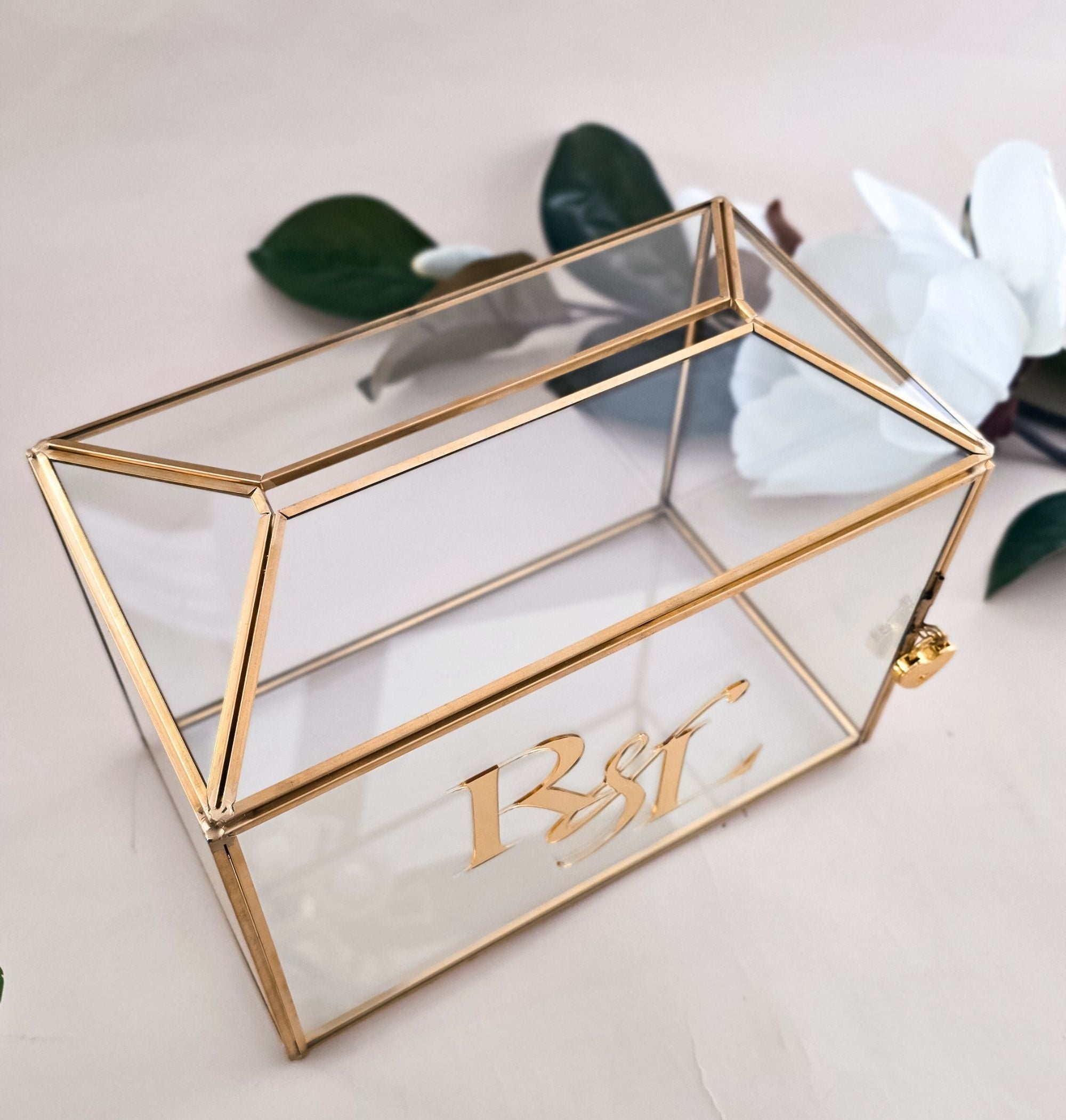 Interior view of glass card box showing raised 3D gold mirror acrylic monogram standing upright among wedding cards and white paper crinkle filler