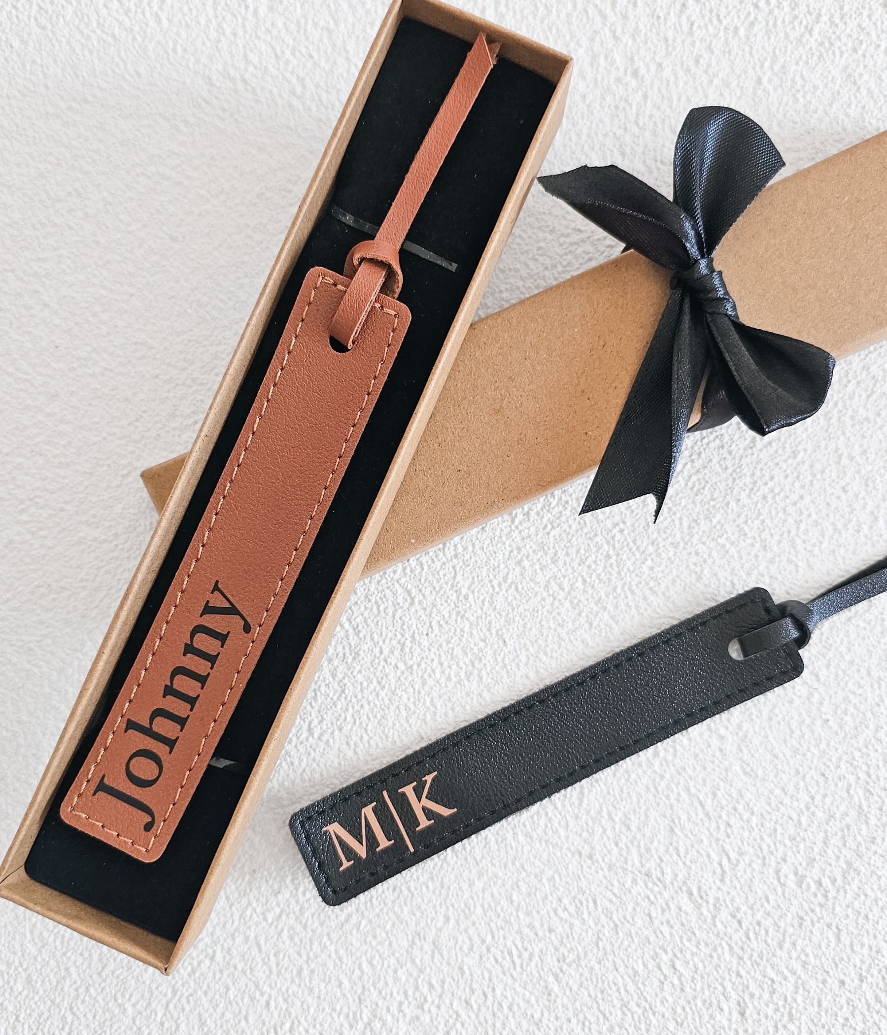 Brown personalized faux leather bookmark with black lettering in a gift box with black bow