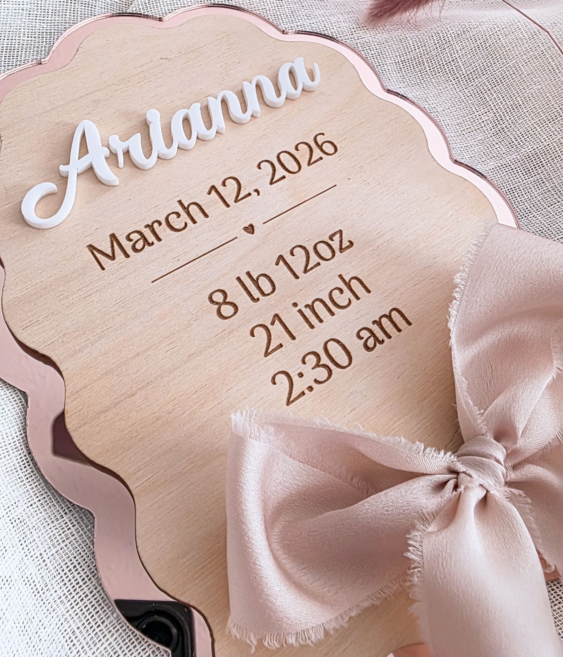 Close-up of white 3D acrylic raised name "Arianna" on birch wood birth stat keepsake sign with rose mirror acrylic backing
