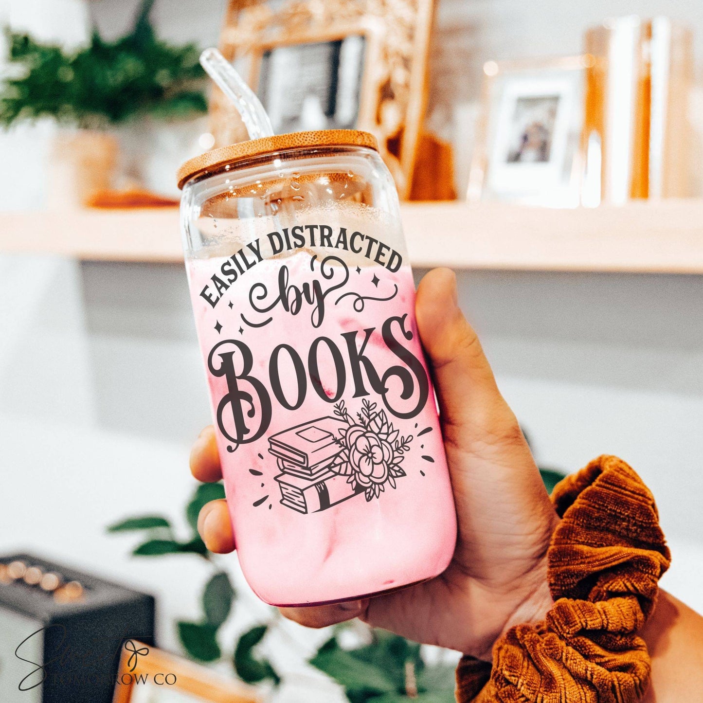 a person holding up a pink book in a jar
