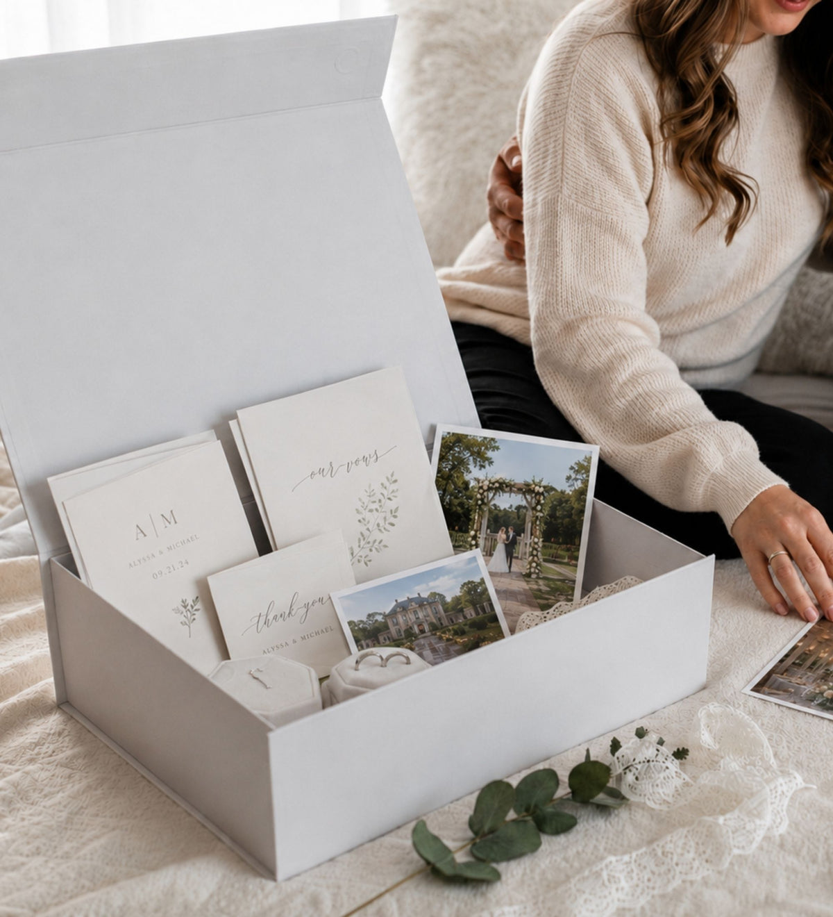 Open keepsake box holding vow books, printed photographs, cards and small velvet boxes