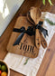 Detail of engraved family name and address on wooden cutting board from kitchen gift set