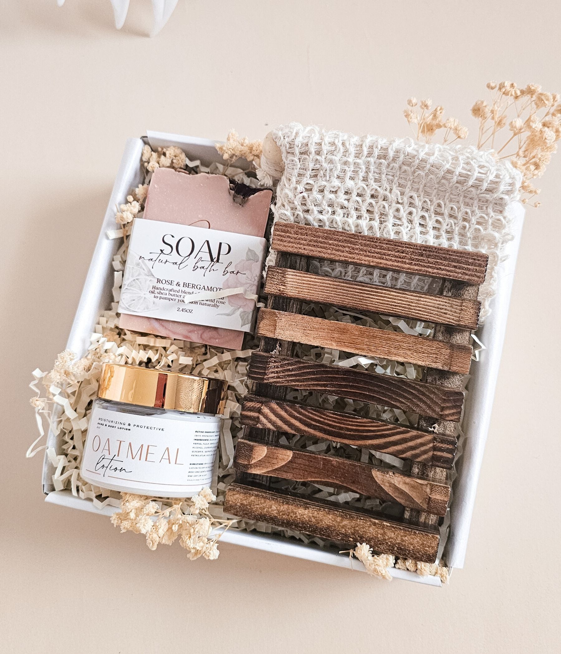 Natural spa gift box with rose and bergamot soap bar, oatmeal body lotion, and wooden soap holder in gift-ready packaging