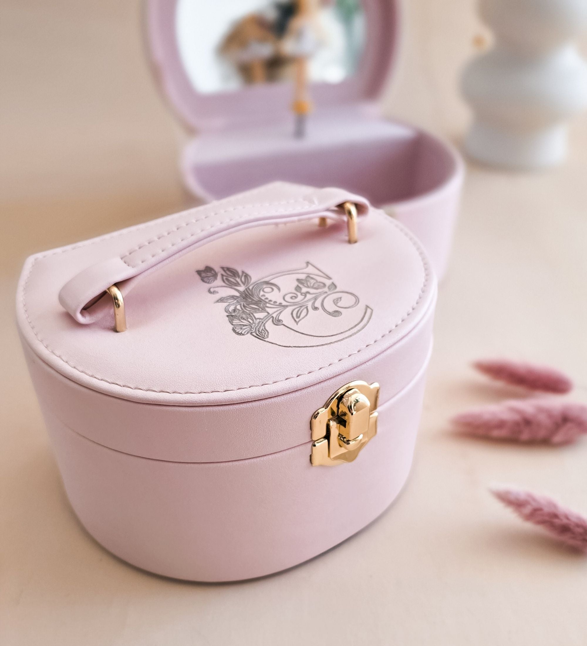 Pink leatherette ballerina music box open showing spinning ballerina figurine in white tutu, full-size oval mirror in lid, soft velvet-lined interior