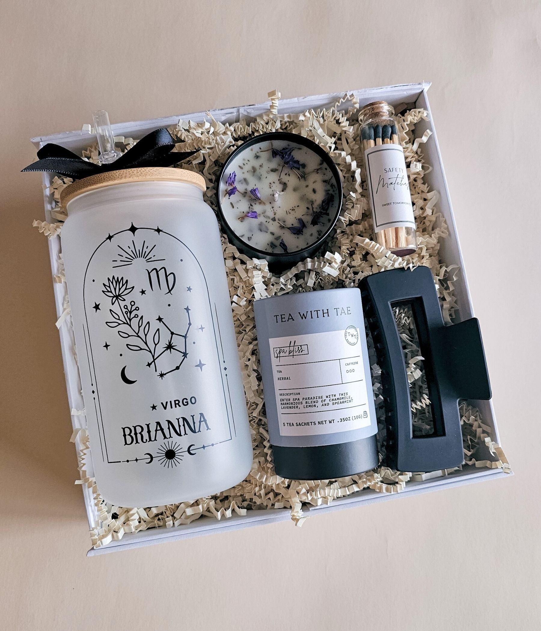 Personalized zodiac gift box with frosted 16oz glass tumbler, engraved bamboo brush, candle, and spa accessories in magnetic box