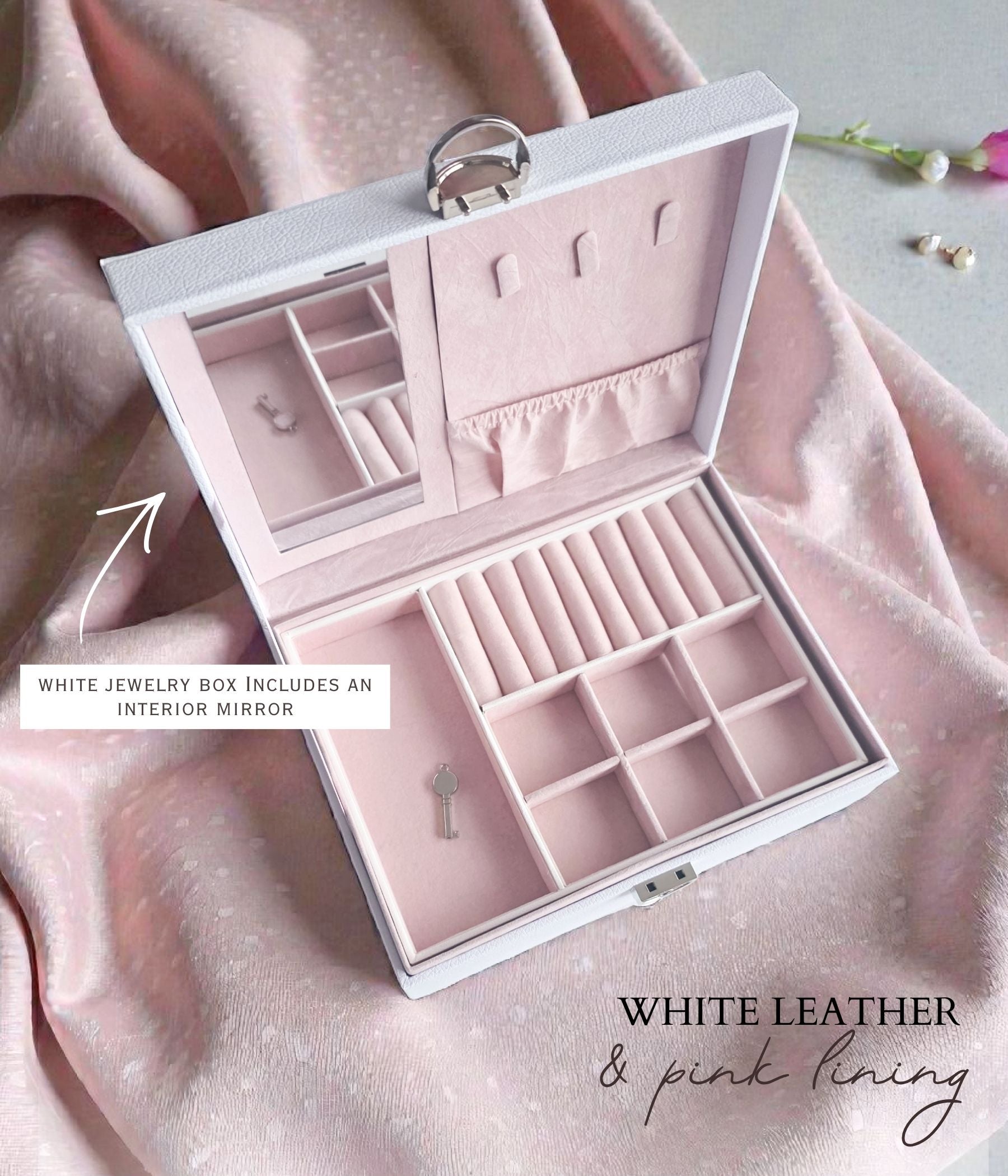 Open white jewelry box with blush pink velvet lining and divided compartments